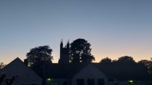 Late evening clear sky view of the Old Boy's School on the Kilkenny Road in Durrow, Laois County. The steeple of the Church is visible behind trees in the background.